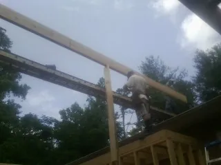 Carpenter setting a ridge beam over a new addition frame — Ice Dam Removal by Roofing Brothers in Tonopah